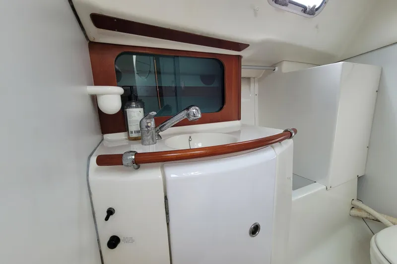 Slide: The Image of 2002 Beneteau Oceanis 311 bathroom with sink, faucet, and wooden accents. - 23