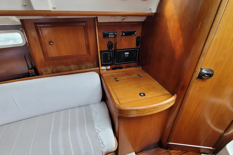 Slide: The Image of Interior of 2002 Beneteau Oceanis 311 sailboat with wooden cabinetry and navigation equipment. - 26