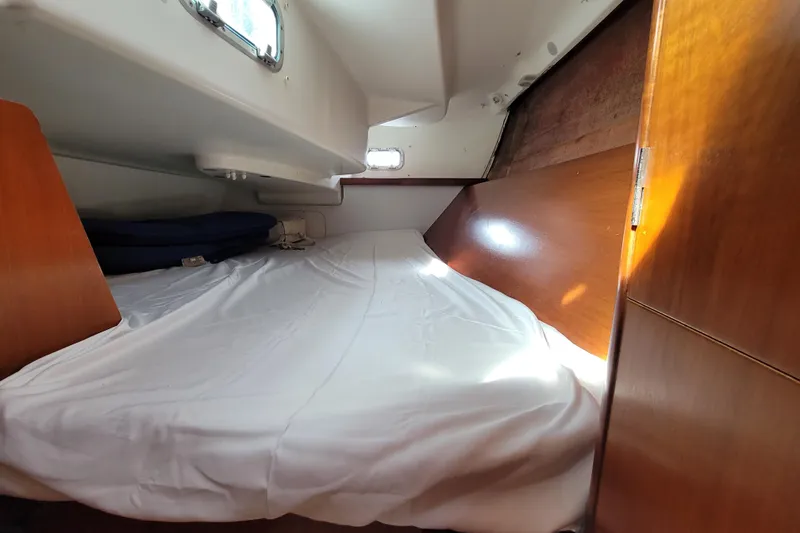 Slide: The Image of Cozy cabin interior of 2002 Beneteau Oceanis 311 sailboat with wooden accents and bedding. - 29