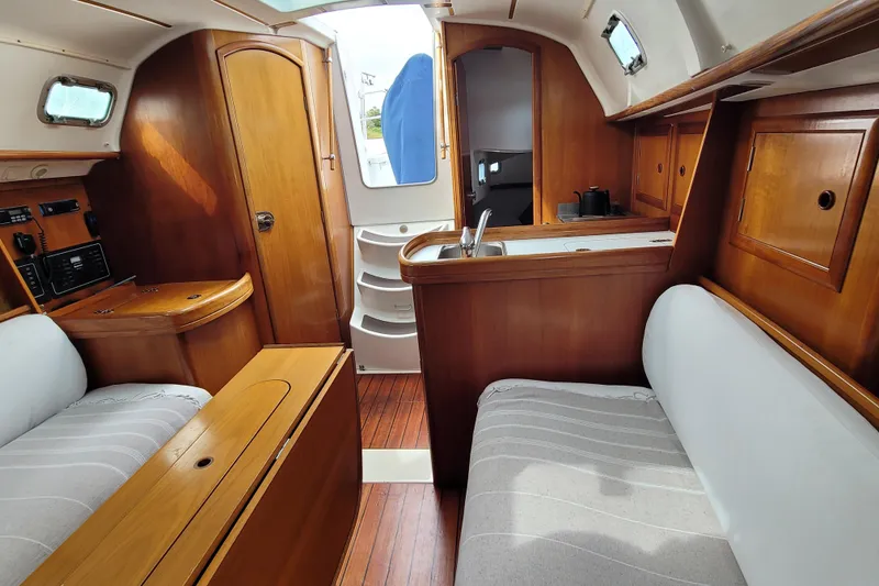 Slide: The Image of Interior of 2002 Beneteau Oceanis 311 sailboat with wooden cabinetry and seating. - 31