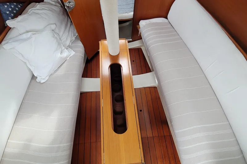 Slide: The Image of Interior of 2002 Beneteau Oceanis 311 sailboat with wooden flooring and cushioned seating. - 32