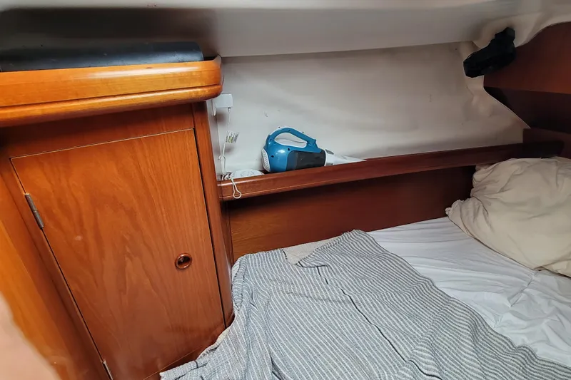 Slide: The Image of Cozy cabin interior of 2002 Beneteau Oceanis 311 sailboat with wooden cabinetry and bedding. - 34