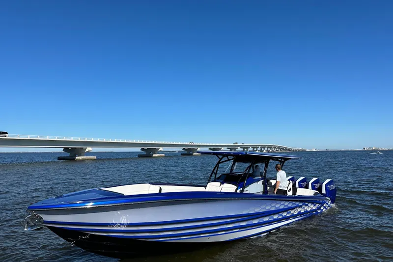 Slide: The Image of 2025 Nor-Tech 390 Sport boat on water near a bridge, clear blue sky. - 10