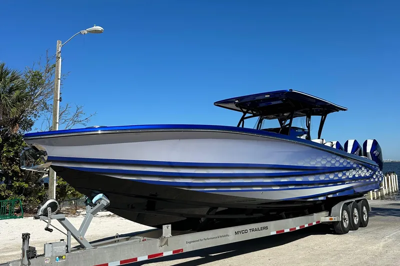 Slide: The Image of 2025 Nor-Tech 390 Sport boat on trailer, sleek design, blue accents, clear sky background. - 12