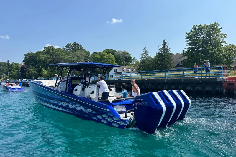 Slide: The Image of 2025 Nor-Tech 390 Sport boat with quad engines on a sunny day near a dock. - 13