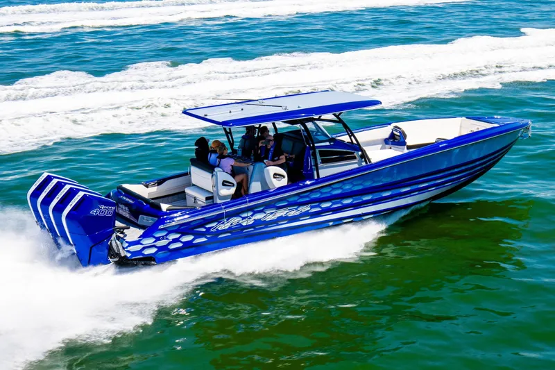 Slide: The Image of 2025 Nor-Tech 390 Sport boat cruising on open water, vibrant blue design. - 2