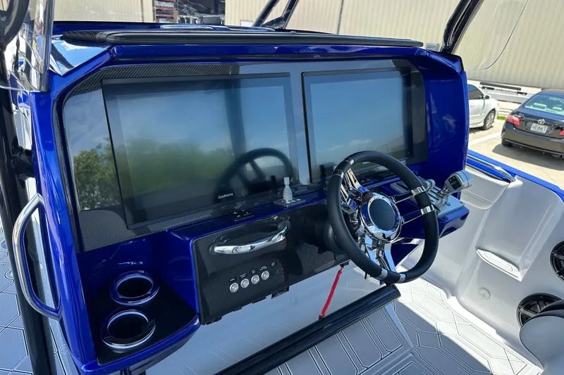 Slide: The Image of 2025 Nor-Tech 390 Sport boat dashboard with dual screens and modern steering wheel. - 29