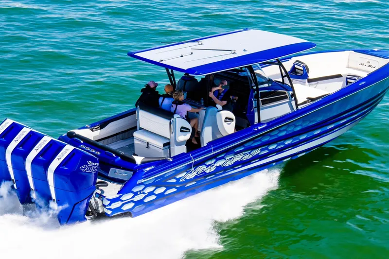 Slide: The Image of 2025 Nor-Tech 390 Sport boat cruising on water, featuring vibrant blue design and powerful engines. - 3