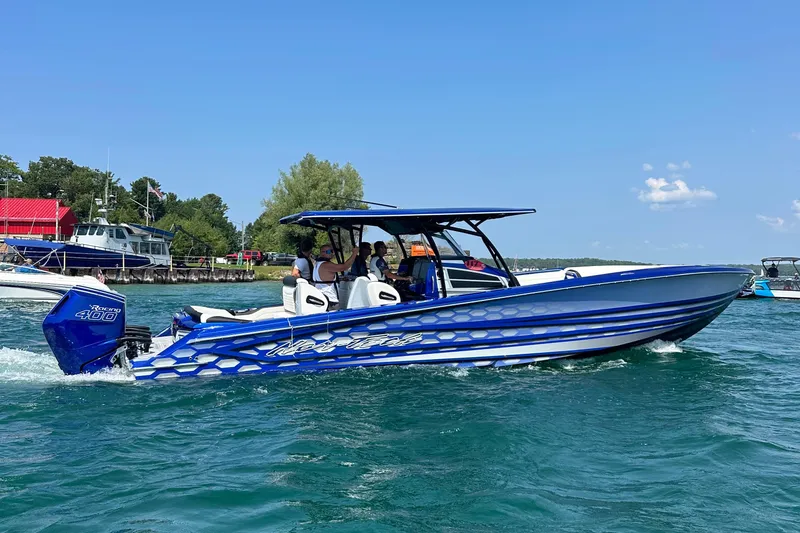 Slide: The Image of 2025 Nor-Tech 390 Sport boat cruising on clear blue water under a sunny sky. - 5