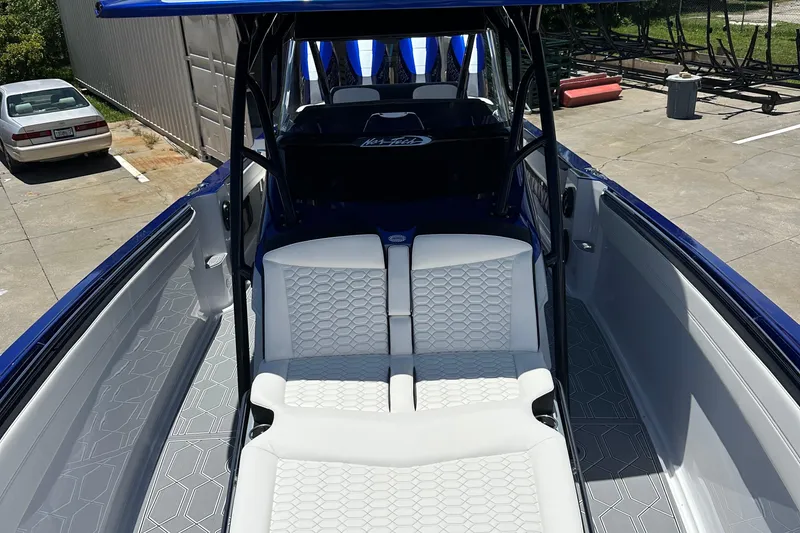 Slide: The Image of 2025 Nor-Tech 390 Sport boat interior with white seating and geometric flooring design. - 23