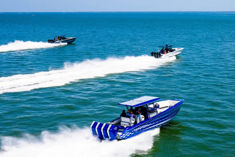 Slide: The Image of 2025 Nor-Tech 390 Sport boats racing on open water, showcasing speed and performance. - 4