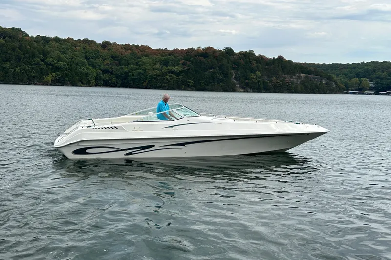 Slide: The Image of 1999 Envision 3200 Intruder boat on a lake with forested shoreline. - 11