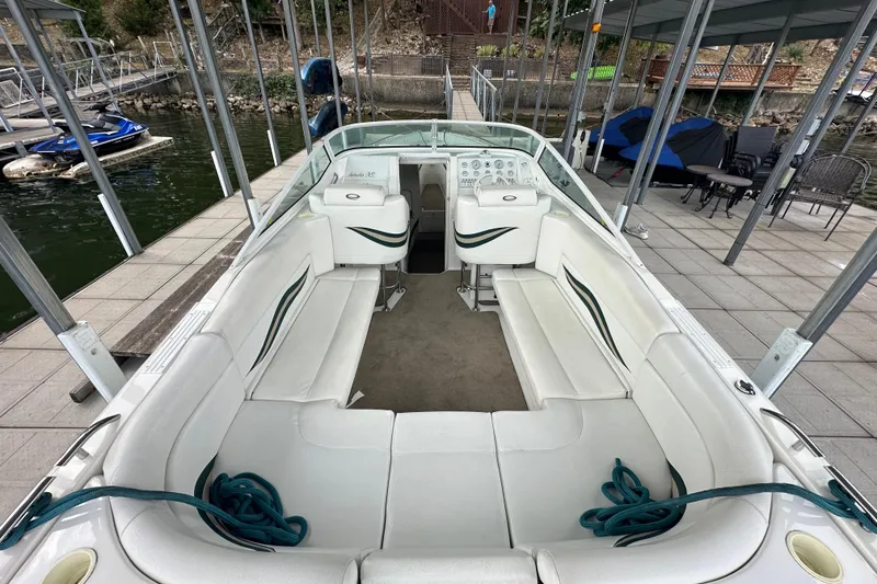 Slide: The Image of 1999 Envision 3200 Intruder boat with white seating, docked at a marina. - 12