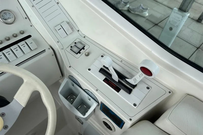 Slide: The Image of Control panel of a 1999 Envision 3200 Intruder boat with steering wheel and throttle levers. - 15