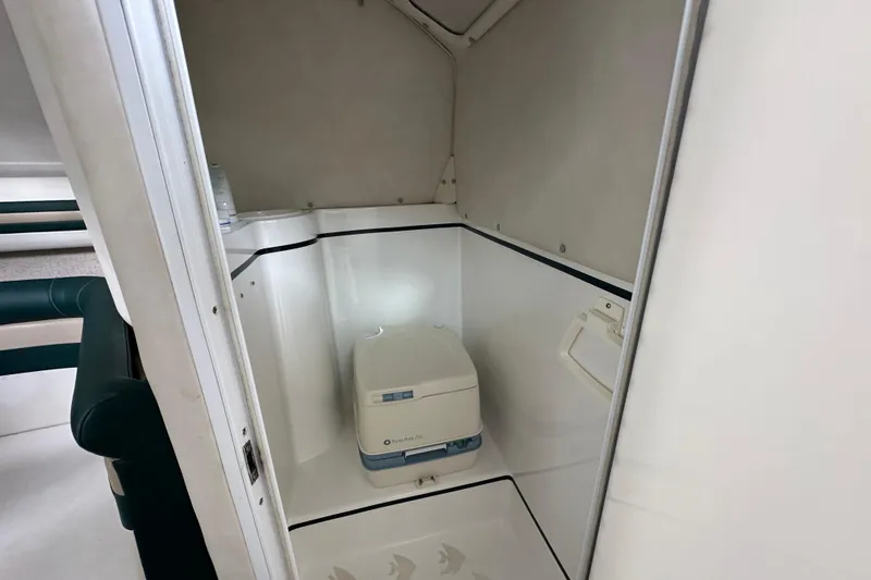 Slide: The Image of Interior of 1999 Envision 3200 Intruder boat with compact toilet area. - 21