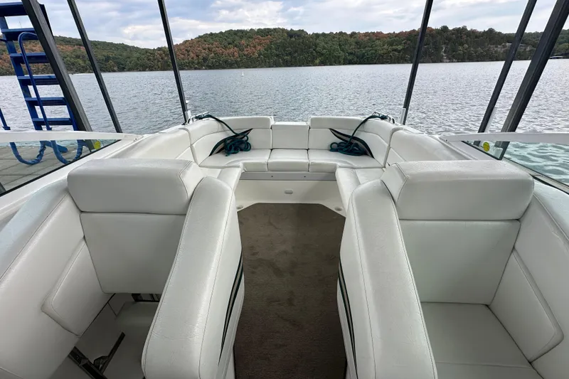 Slide: The Image of Interior of 1999 Envision 3200 Intruder boat with white seating and lake view. - 26
