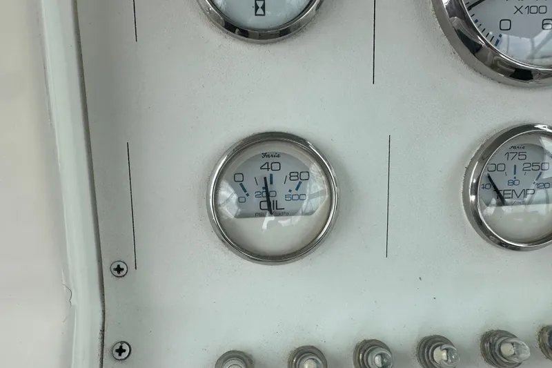 Slide: The Image of Instrument panel of a 1999 Envision 3200 Intruder boat, featuring gauges and switches. - 28