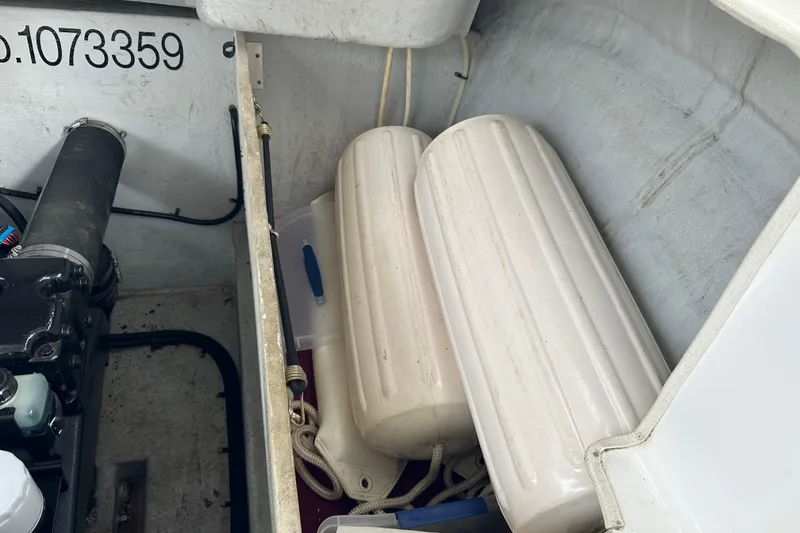 Slide: The Image of Interior of 1999 Envision 3200 Intruder boat showing engine compartment and fenders. - 32