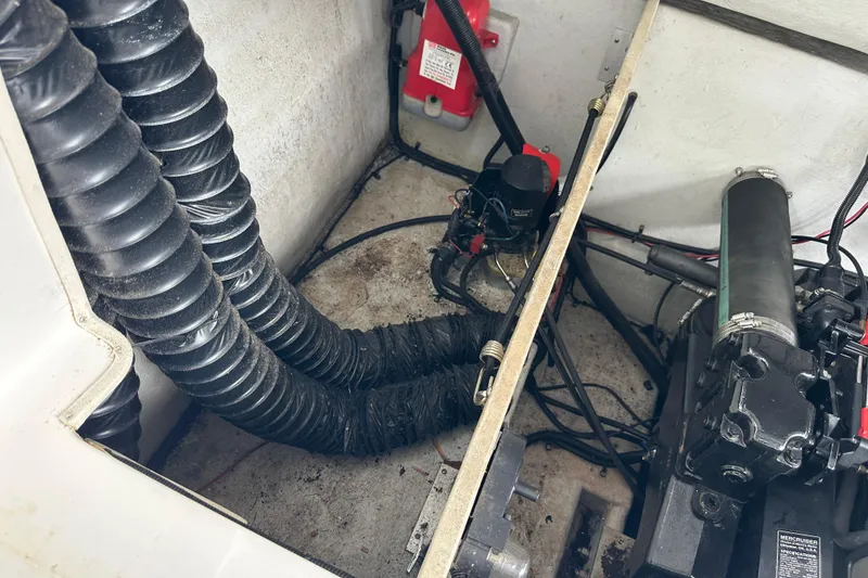 Slide: The Image of Engine compartment of a 1999 Envision 3200 Intruder boat, showing hoses and mechanical components. - 33