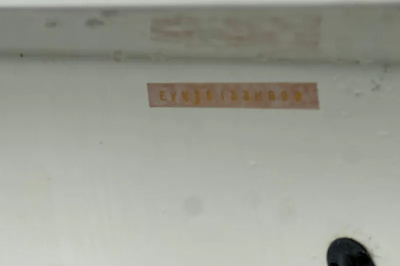 Slide: The Image of 1999 Envision 3200 Intruder hull identification number on white surface. - 34