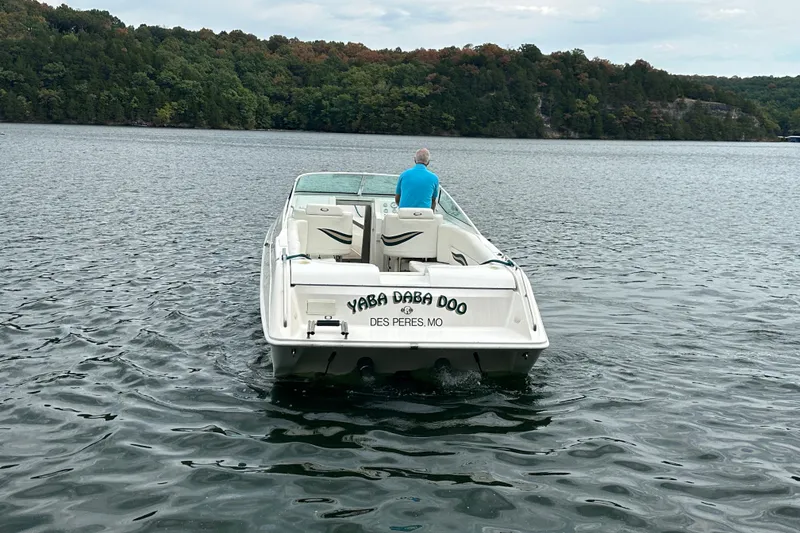 Slide: The Image of Man steering 1999 Envision 3200 Intruder boat on a scenic lake. - 7