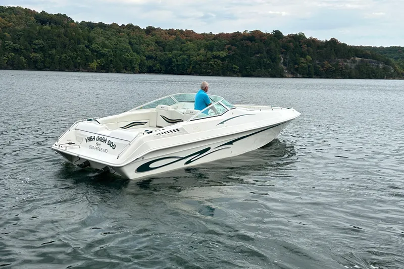 Slide: The Image of 1999 Envision 3200 Intruder boat on a lake with forested shoreline. - 9