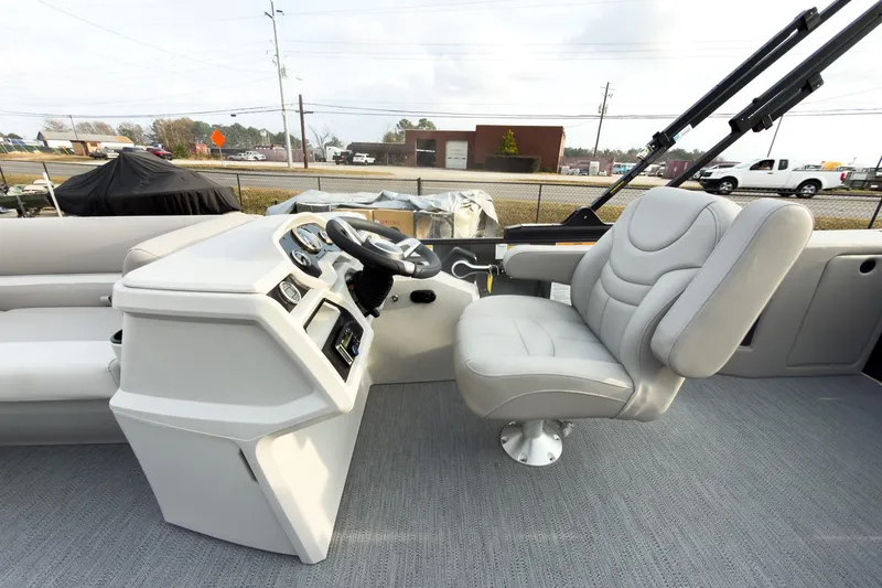 Slide: The Image of 2026 Godfrey Sweetwater Xperience 22' Tritoon helm with plush captain's chair and modern controls. - 16