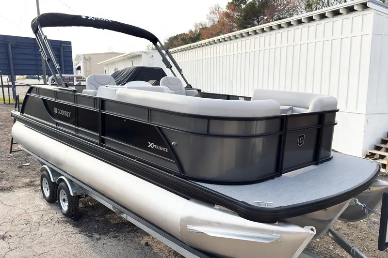 The Image of 2026 Godfrey Sweetwater Xperience 22' Tritoon with single flip lounge, parked on trailer. - 2