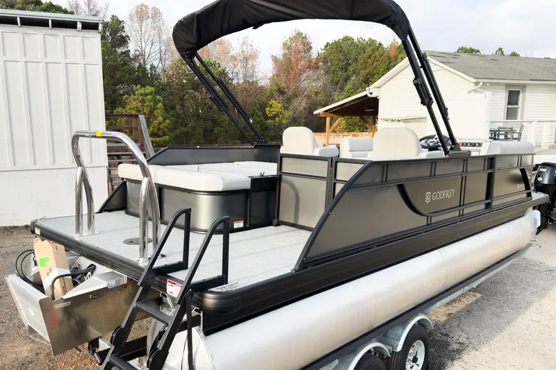 Slide: The Image of 2026 Godfrey Sweetwater Xperience 22' Tritoon with flip lounge, parked outdoors. - 5