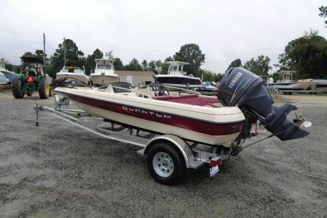 The Image of 1996 Quantum 180 XD boat with Yamaha outboard motor on trailer, parked outdoors. - 0