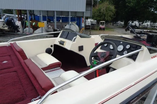 Slide: The Image of 1996 Quantum 180 XD boat interior with maroon seating and dashboard controls. - 10