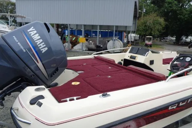 Slide: The Image of 1996 Quantum 180 XD boat with Yamaha outboard motor, red interior, docked near a shed. - 11
