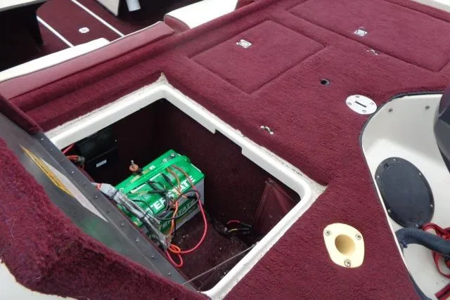 Slide: The Image of 1996 Quantum 180 XD boat interior with open battery compartment, red carpet, and wiring visible. - 12