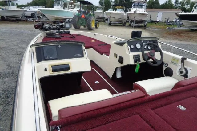Slide: The Image of 1996 Quantum 180 XD boat with maroon interior, parked among other boats. - 13