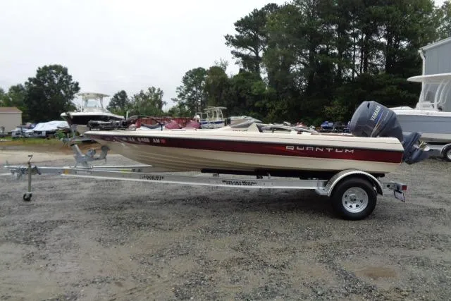 Slide: The Image of 1996 Quantum 180 XD boat on trailer, parked outdoors with trees in background. - 5