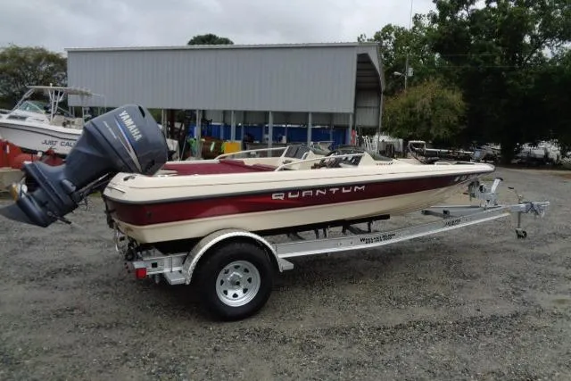 Slide: The Image of 1996 Quantum 180 XD boat on trailer with Yamaha outboard motor, parked outdoors. - 7