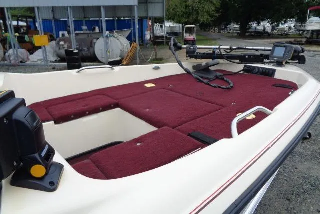 Slide: The Image of 1996 Quantum 180 XD boat with maroon interior, featuring storage compartments and fishing equipment. - 9