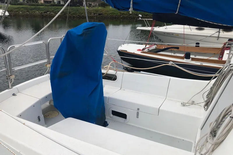 Slide: The Image of 1995 Catalina 270 sailboat cockpit with blue cover, docked near other boats. - 15