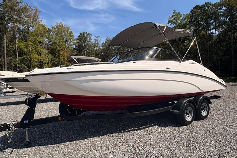 The Image of 2018 Yamaha SX210 boat on trailer, parked outdoors with trees in background. - 0