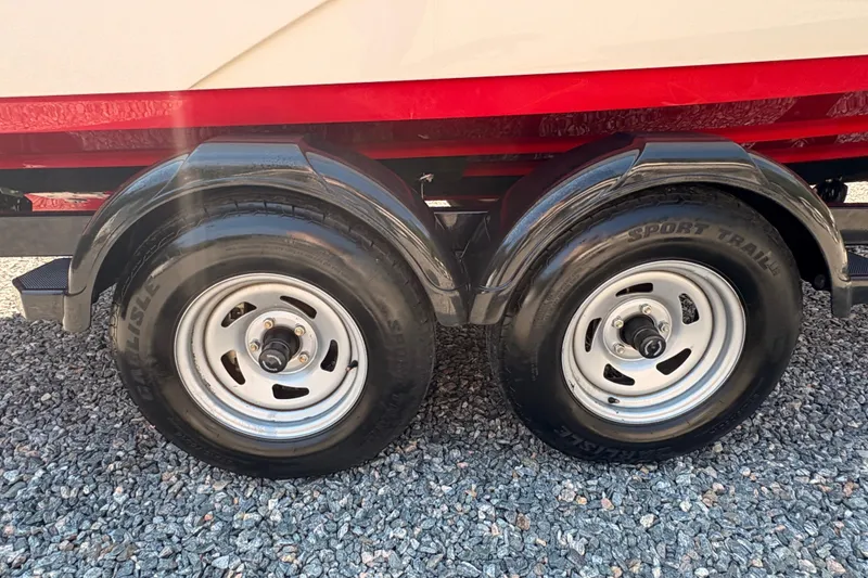 Slide: The Image of 2018 Yamaha Boats SX210 trailer wheels on gravel surface. - 3