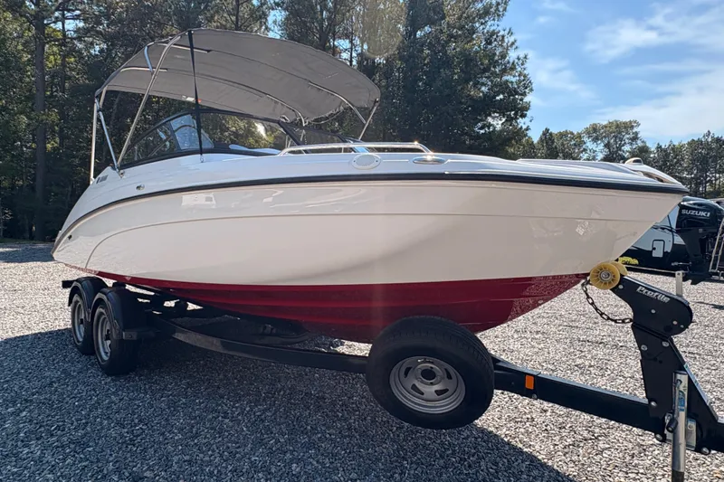 Slide: The Image of 2018 Yamaha Boats SX210 on trailer, parked outdoors under a clear sky. - 4