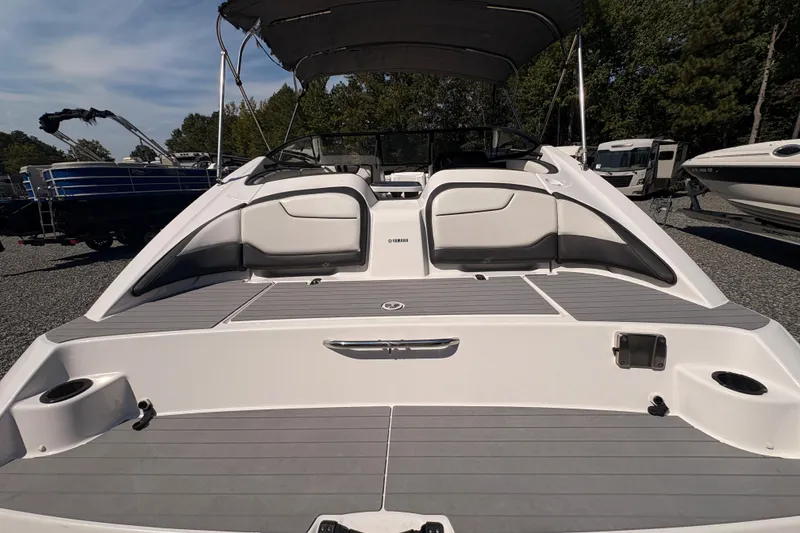 Slide: The Image of 2018 Yamaha Boats SX210 with spacious seating and sleek design, parked outdoors. - 6