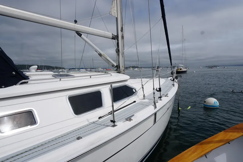 Slide: The Image of 2006 Hunter 41 Deck Salon sailboat docked on calm water under cloudy skies. - 3