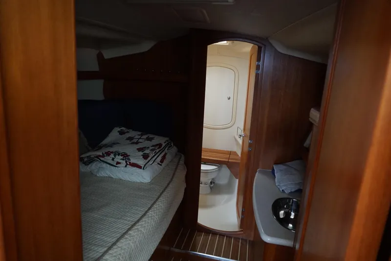 Slide: The Image of Interior of 2006 Hunter 41 Deck Salon with cozy bed and compact bathroom. - 6
