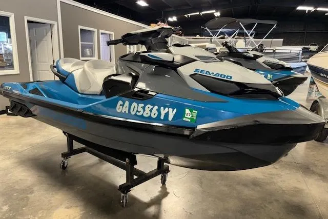 Slide: The Image of 2018 Sea-Doo GTX 155 jet ski in showroom, blue and gray design. - 1