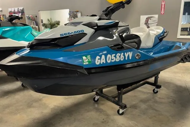 Slide: The Image of 2018 Sea-Doo GTX 155 jet ski in showroom, blue and black design. - 10