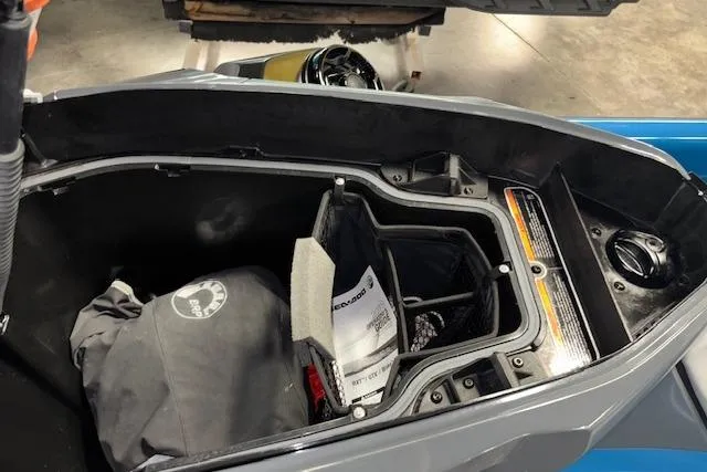 Slide: The Image of Open storage compartment of 2018 Sea-Doo GTX 155 with gear and manual inside. - 16
