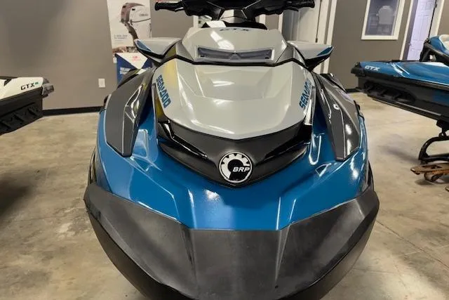 Slide: The Image of 2018 Sea-Doo GTX 155 jet ski in showroom, front view, blue and gray design. - 17