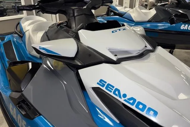 Slide: The Image of 2018 Sea-Doo GTX 155 jet ski in showroom, featuring sleek blue and white design. - 18