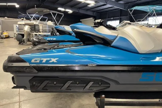 Slide: The Image of 2018 Sea-Doo GTX 155 jet ski in a showroom, featuring a sleek blue design. - 2